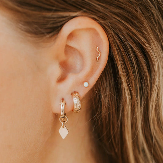 Gold tiny wave ear climbers on models ear
