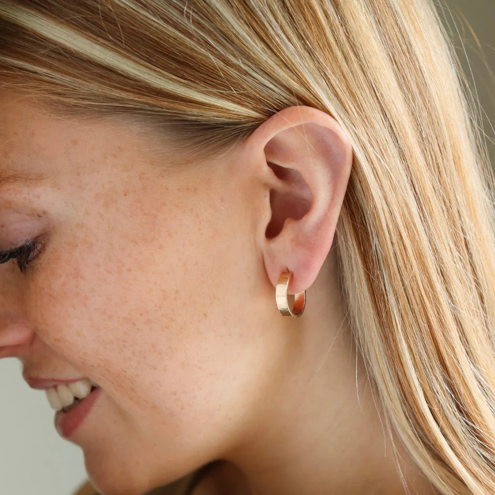 Small mirage hoops in 14k gold filled on models ear