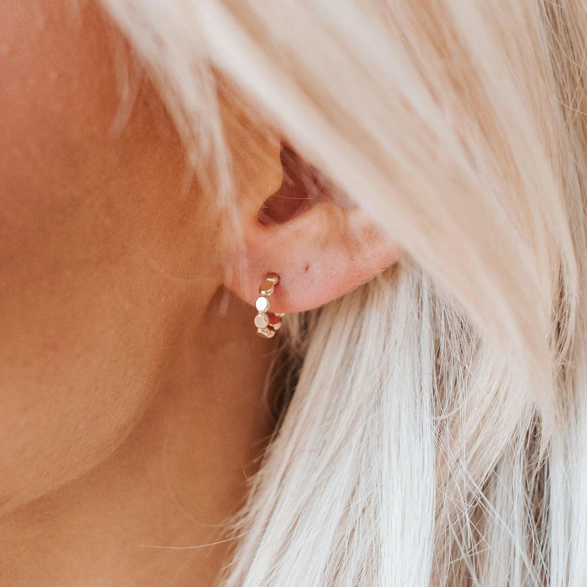 Gold cora huggies on models ear